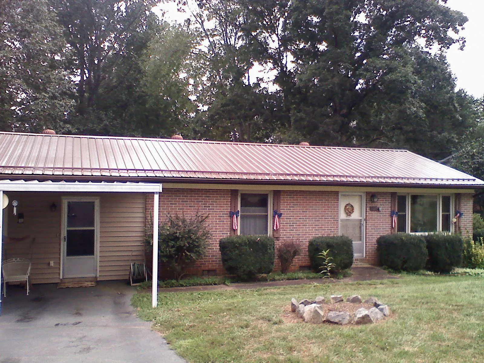 Bronze metal roof and carport on a brick ranch home — Roof Repair work by our crew in Salado