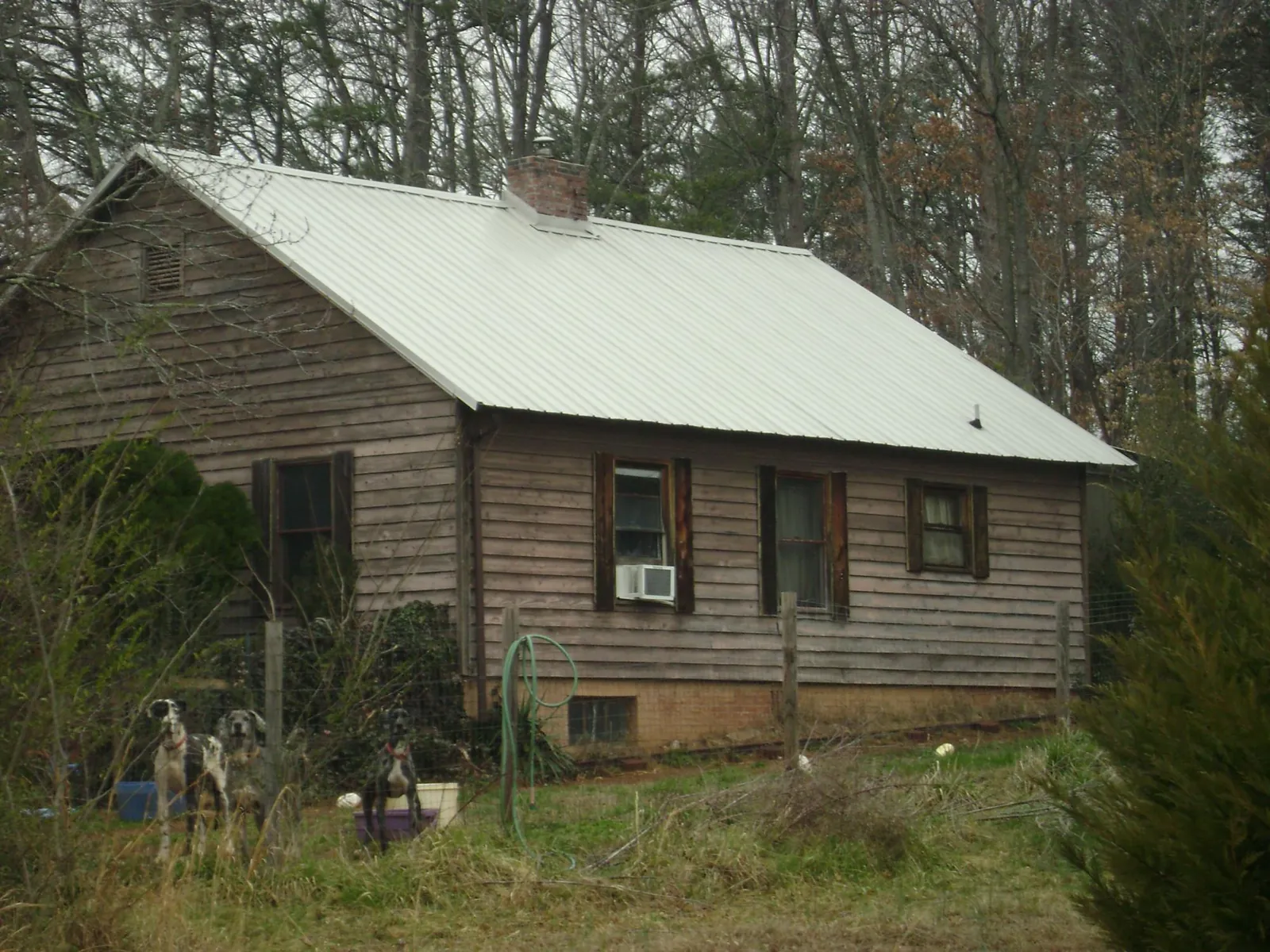 White metal roof on an old wood sided farmhouse, from a Metal Roof Installation job in Salado